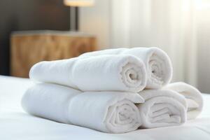 AI generated stack of neatly folded white towels on a bed in a hotel room photo