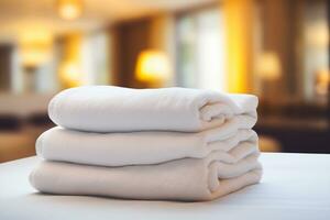 AI generated stack of neatly folded white towels on a bed in a hotel room photo