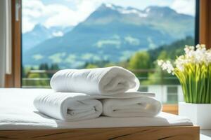 AI generated a stack of white towels on a bed in a hotel room, against the backdrop of a panoramic window overlooking green alpine meadows photo