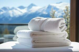 AI generated a stack of white towels on a bed in a hotel room, against the backdrop of a panoramic window overlooking green alpine meadows photo