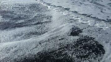 Grey sand beach with water flow. photo