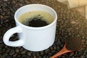 Cup of coffee on coffee beans background. photo