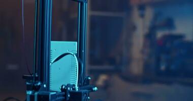 Modern 3D printer creating detail in dark room with neon illumination video