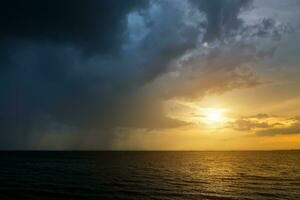 Dark Clouds and rain are falling in the sea. photo