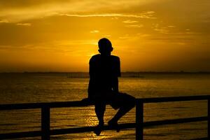 Silhouette of a lonely man at sunset photo