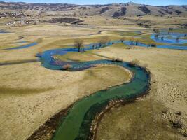 Aerial drone view of an amazing beautiful serpentine river. Vibrant colors and beautiful landscape. Background and textures. Nature and beautiful scenery. River Suica in Bosnia and Herzegovina. photo