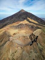 Aerial view of Pico Viejo volcano with Mount Teide in the background in Tenerife, Canary Islands, Spain. Pico Viejo has a spectacular 800 meters diameter crater. Famous destinations for hikers. photo