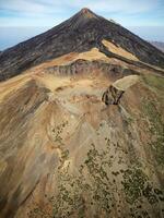 Aerial view of Pico Viejo volcano with Mount Teide in the background in Tenerife, Canary Islands, Spain. Pico Viejo has a spectacular 800 meters diameter crater. Famous destinations for hikers. photo