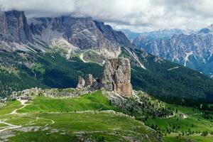 View of Cinque Torri with the Tofane mountain in the background covered with clouds. Famous climbing and alpinist place in the Dolomites, Italy. Travel destinations. photo