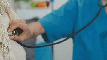 Close up of Female Doctor using stethoscope putting beat heart diagnose with patient in examination room at a hospital, check-up body, Medical and Health Care Concept. video