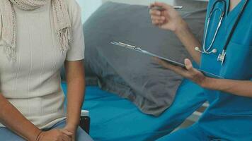 donne asiatico medici hold il paziente mano e incoraggiare e fornire medico consigli mentre controllo il paziente Salute nel letto. concetto di cura e compassione, prenatale cura, minacciato aborto video