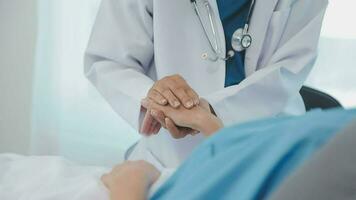 Female doctor in white coat holding hand of senior patient, giving help, comfort, psychological support, empathy at appointment. Elderly medic care, geriatric healthcare concept. Close up video