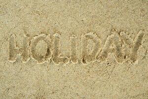 Holiday handwritten text on sand photo