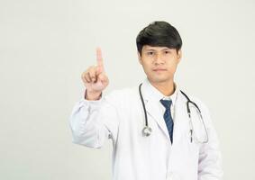 retrato joven hombre asiático estudiante científico o médico uno persona, vistiendo blanco vestido, de pie, mirando y sonriente estetoscopio auscultando el corazón alrededor su cuello. en laboratorio habitación blanco antecedentes foto