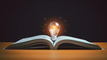 Educational knowledge and business education ideas, glowing light bulb on a book, Inspiring from read concept, self-learning, knowledge and searching for new ideas, Thinking for new idea, Innovations. photo