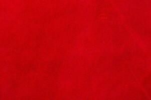 Macro texture of a piece of red suede. Red natural dyed suede as a background. photo