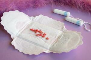 Menstrual pads and tampons on lilac background. photo