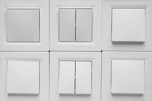 Many light switch, a plastic mechanical switch of white color. photo