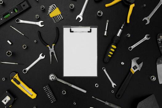 Notebook for writing, around various work tools on a black background. photo