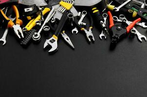 Many different tools for repair work on a black background with copy space for text. photo