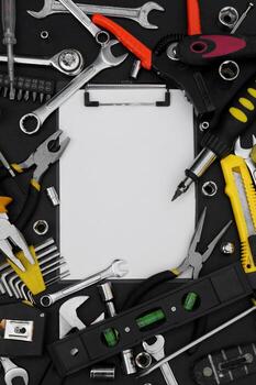 Notebook for writing, around various work tools on a black background. photo