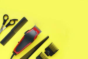 Hair clipper close-up on a yellow background with nozzles of different sizes. photo