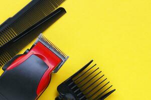 Hair clipper close-up on a yellow background with nozzles of different sizes. photo