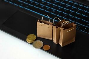 Small craft bags for purchases on the background of the keyboard. photo