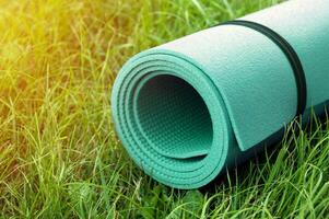 Yoga, fitness or tourist mat on the green grass. photo