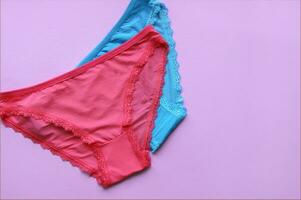 Set of women's panties on a pink background. Pink and blue underwear. photo