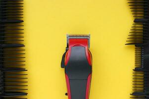 Hair clipper close-up on a yellow background with nozzles of different sizes. photo