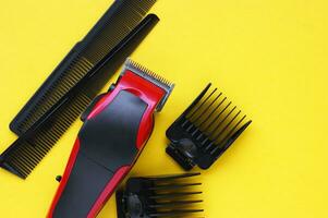 Hair clipper close-up on a yellow background with nozzles of different sizes. photo