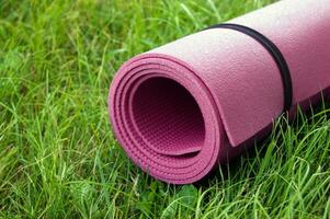 Yoga, fitness or tourist mat on the green grass. photo