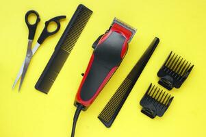 Hair clipper close-up on a yellow background with nozzles of different sizes. photo