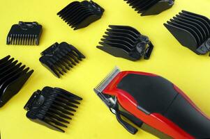 Hair clipper close-up on a yellow background with nozzles of different sizes. photo