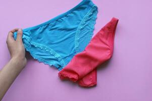 Set of women's panties on a pink background. Pink and blue underwear. photo