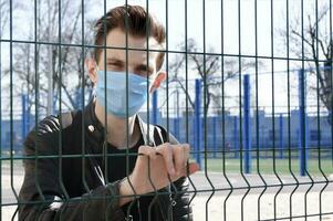 Image of the face of a young man in a mask to prevent the appearance of germs, toxic fumes and dust. photo