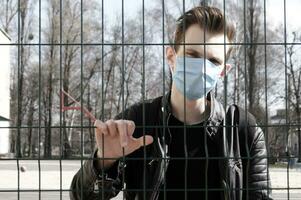 Image of the face of a young man in a mask to prevent the appearance of germs, toxic fumes and dust. photo
