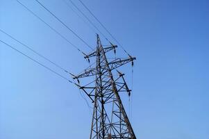 Electricity pylon, electrical transmission tower, against blue sky background. photo