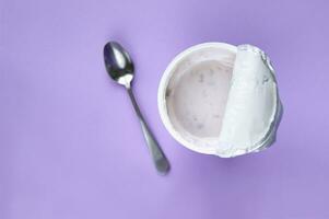 A pink yogurt with strawberry in an open plastic cup on pink background. photo