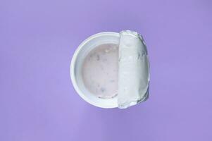 A pink yogurt with strawberry in an open plastic cup on pink background. photo