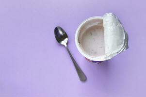 A pink yogurt with strawberry in an open plastic cup on pink background. photo