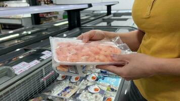 Shopper Choosing Shrimp in Freezer Aisle video