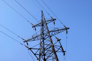 Electricity pylon, electrical transmission tower, against blue sky background. photo