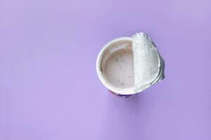 A pink yogurt with strawberry in an open plastic cup on pink background. photo