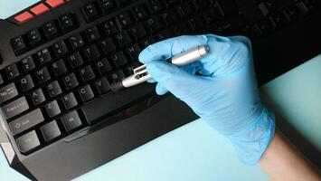 Cleaning the keyboard from dust with a brush in rubber gloves. photo