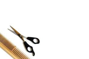 Wooden comb and scissors for a haircut isolated on a white background. photo