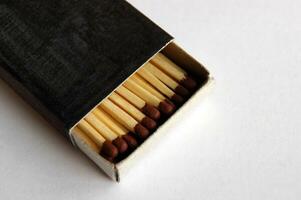 Wooden safety matchsticks stacked in cardboard matchbox. photo