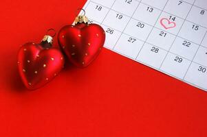 Two red hearts and calendar marked February 14 photo