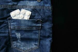 Pills in the back pocket of jeans. photo